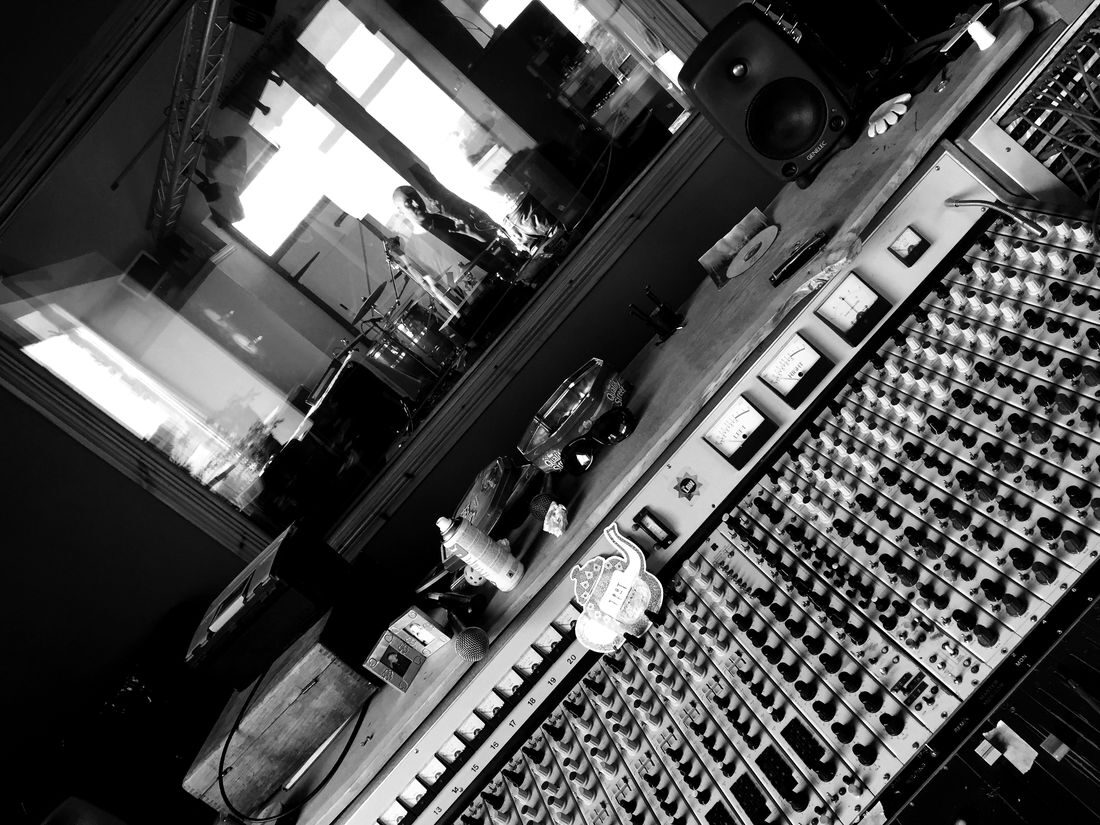 The mixing desk at TPot Studio, with the live room through the window